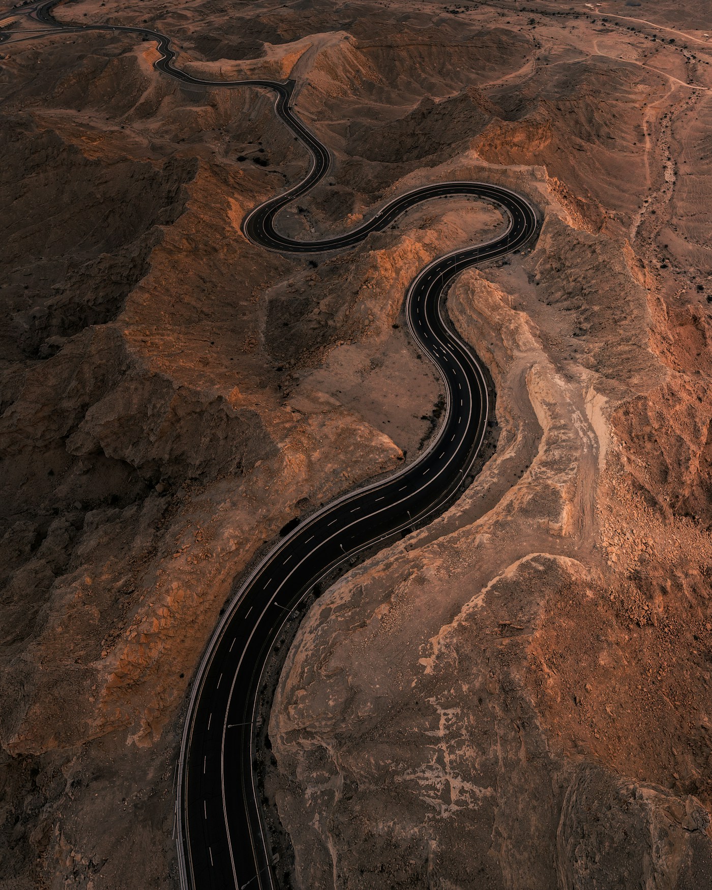 A winding road across dramatic copper-toned mountains